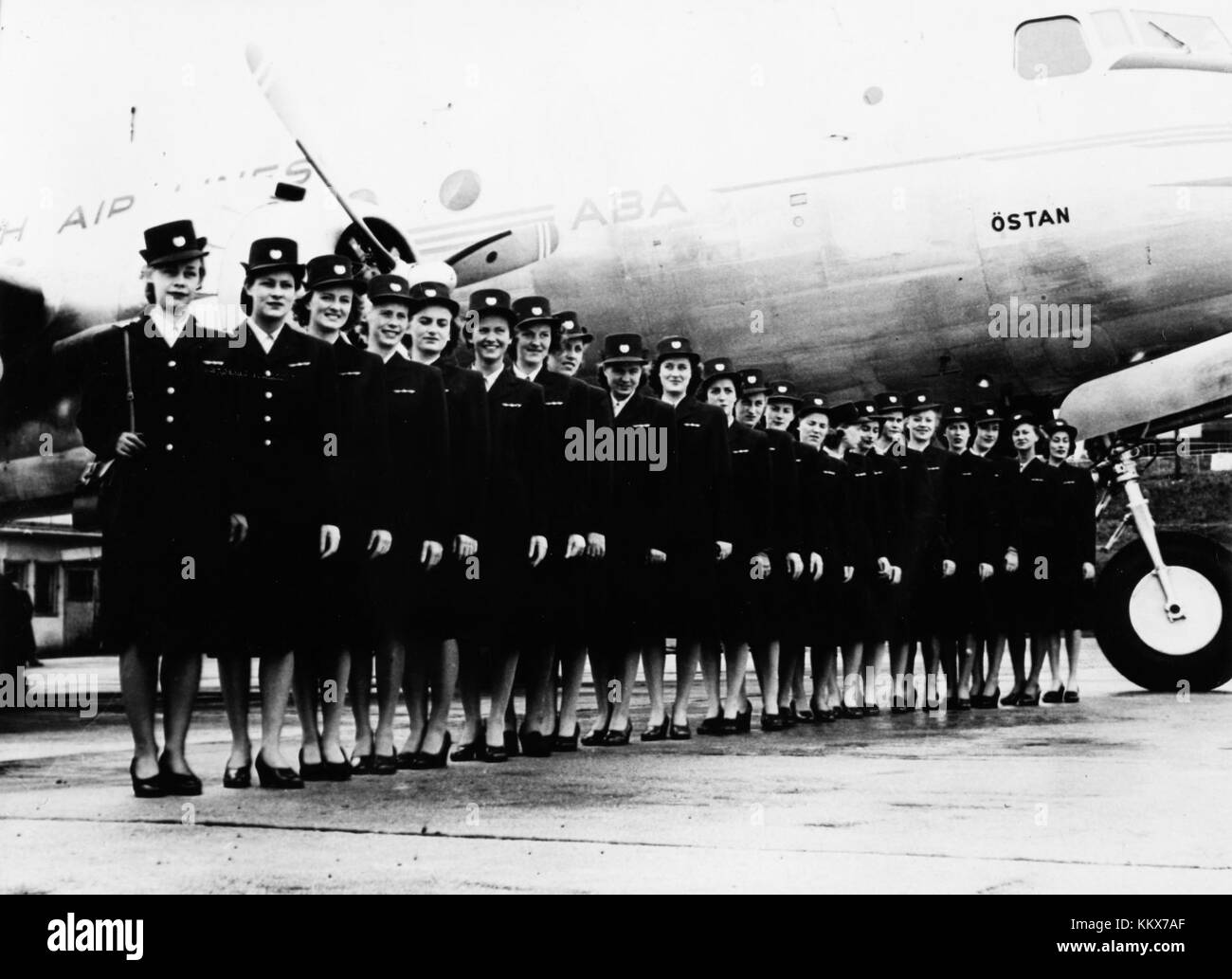 The DC-4 was a four-engine propeller-driven airliner used primarily in the 1940s and 1950s. This image features a DC-4 aircraft along with an air hostess, showcasing early airline travel. Stock Photo