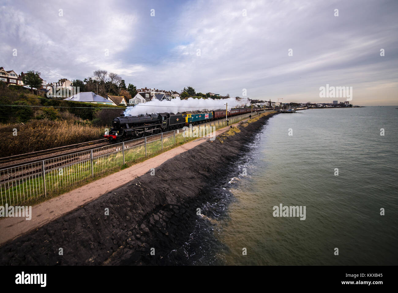 LMS Stanier Black Five 45212 with a vintage diesel class 47 named 'County of Essex' pulling Steam Dreams special train passing Chalkwell Beach on the Thames Estuary Stock Photo