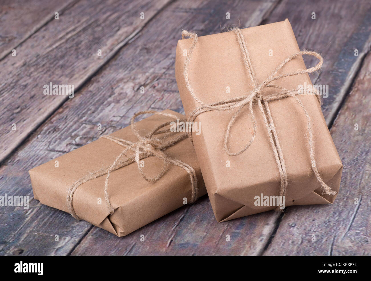 Gifts wrapped in brown paper on a wood textured surface Stock Photo Alamy