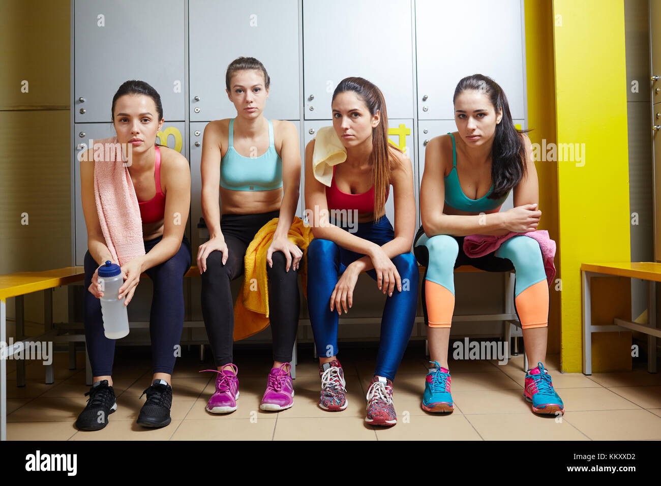 Four Young Women In Activewear Sitting In Dressing Room