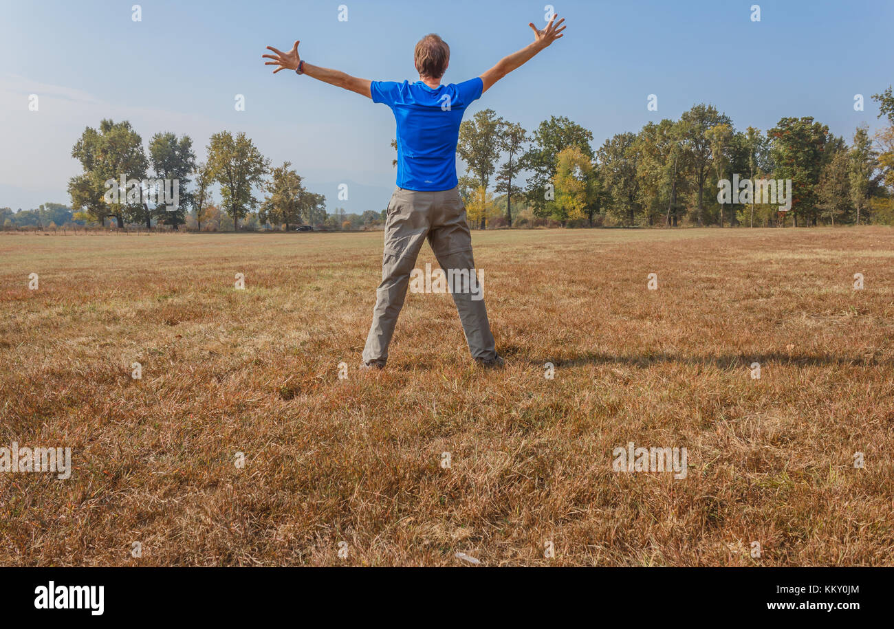 a man is doing gymnastics in a park /a healthy lifestyle of a fifty-years-old man practicing gymnastics in a park Stock Photo