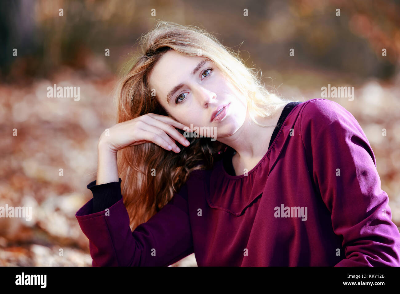 Young woman in beautiful autumn park, concept autumn. Closeup of young blond girl, looking at camera. Stock Photo