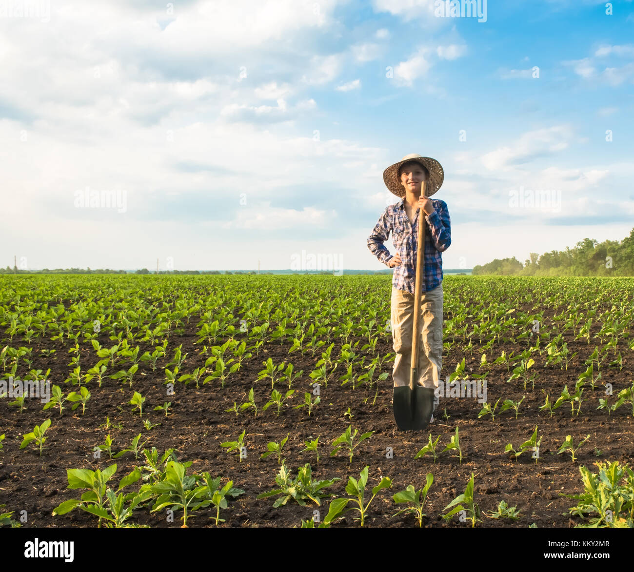 Happy small farmer with spade in spring field gardening Stock Photo