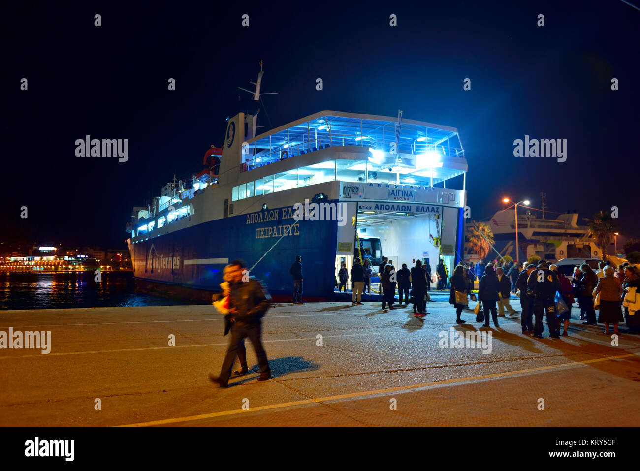 Role on role off ferry to Aegina at night in Pireas harbour, Athens, Greece, with disembarking passengers and vehicles Stock Photo