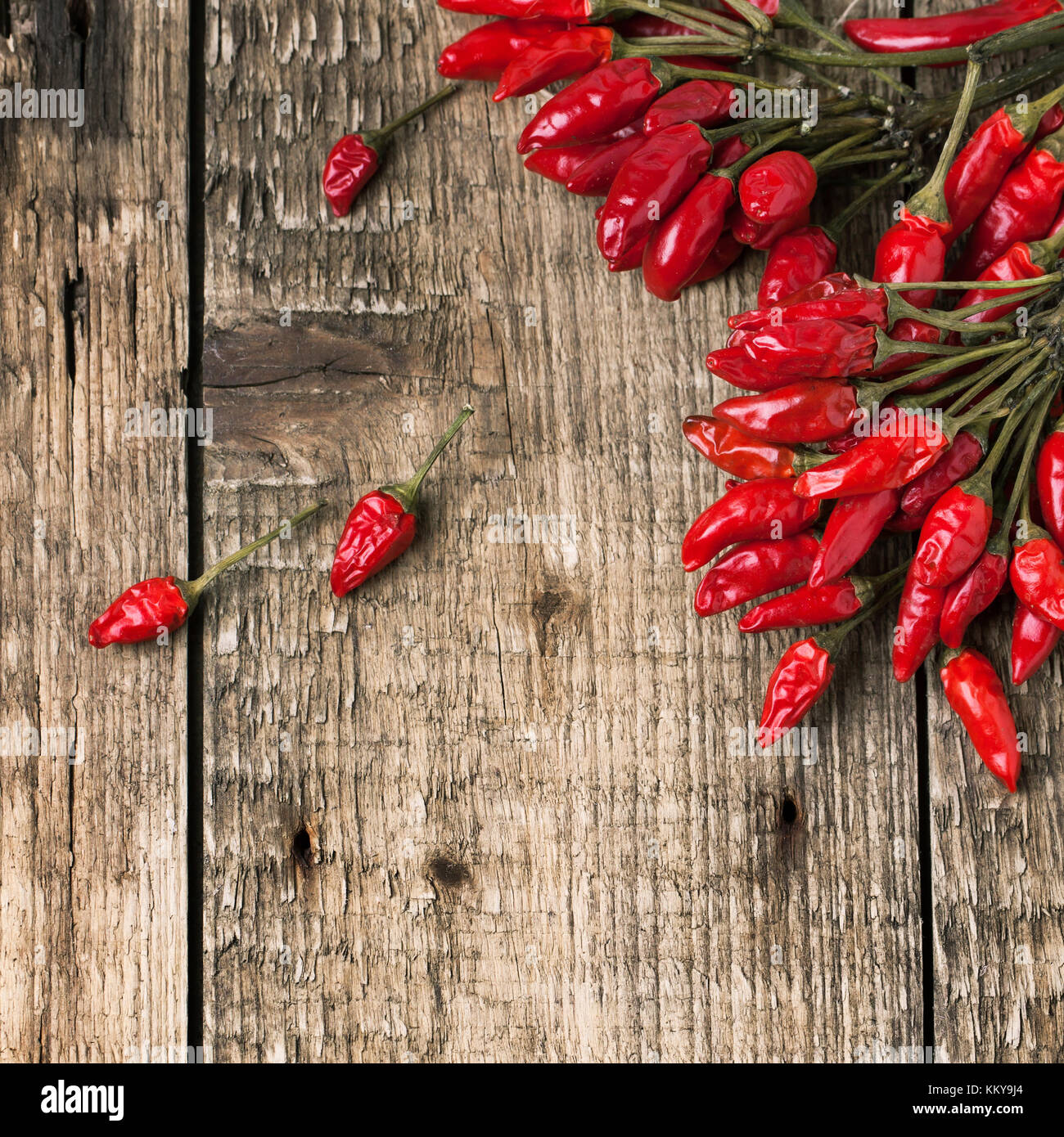 Top view on bunch of red hot chili peppers over old wooden background ...
