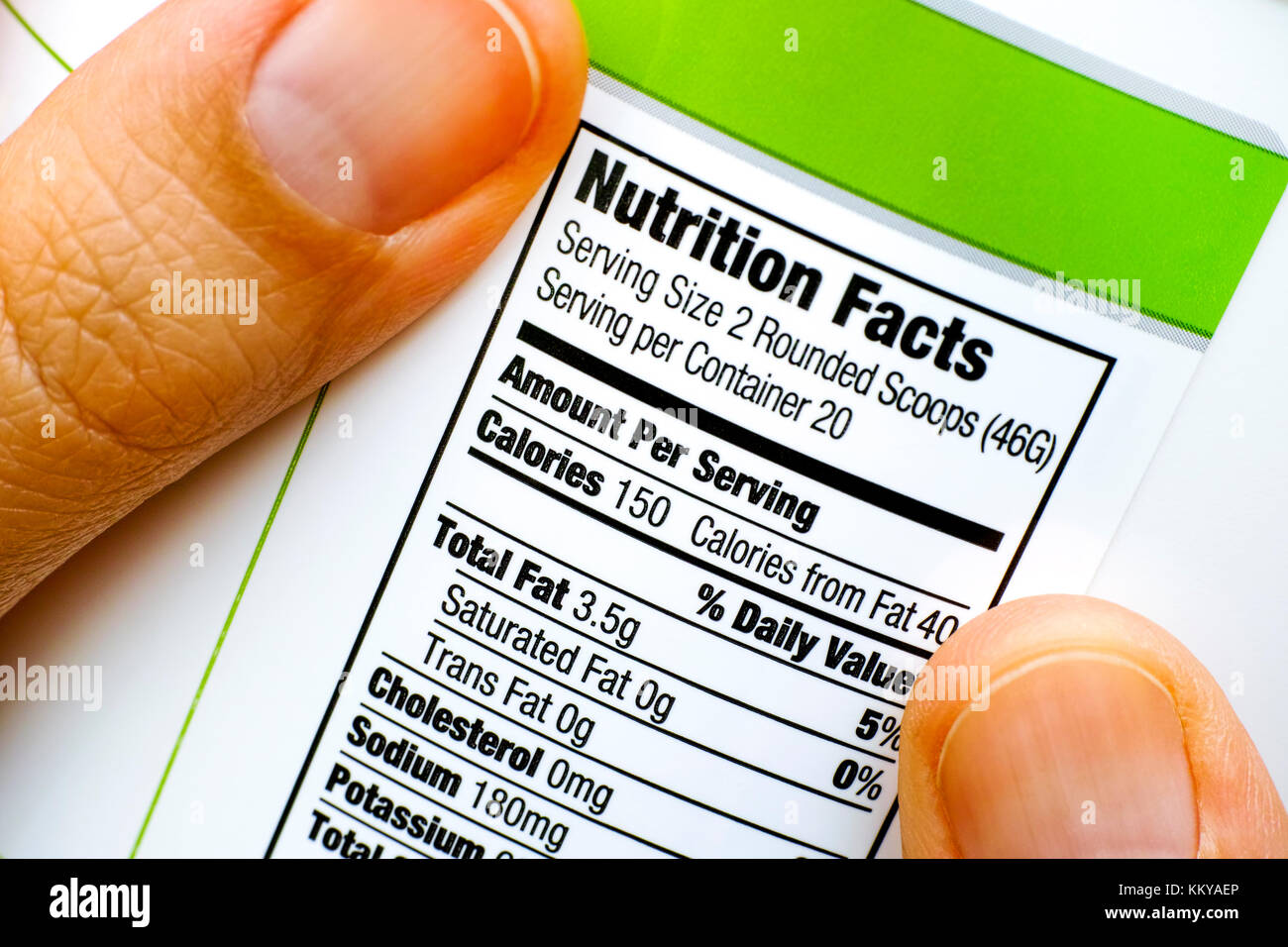 Woman fingers with protein jar. Reading nutrition facts. Closeup Stock