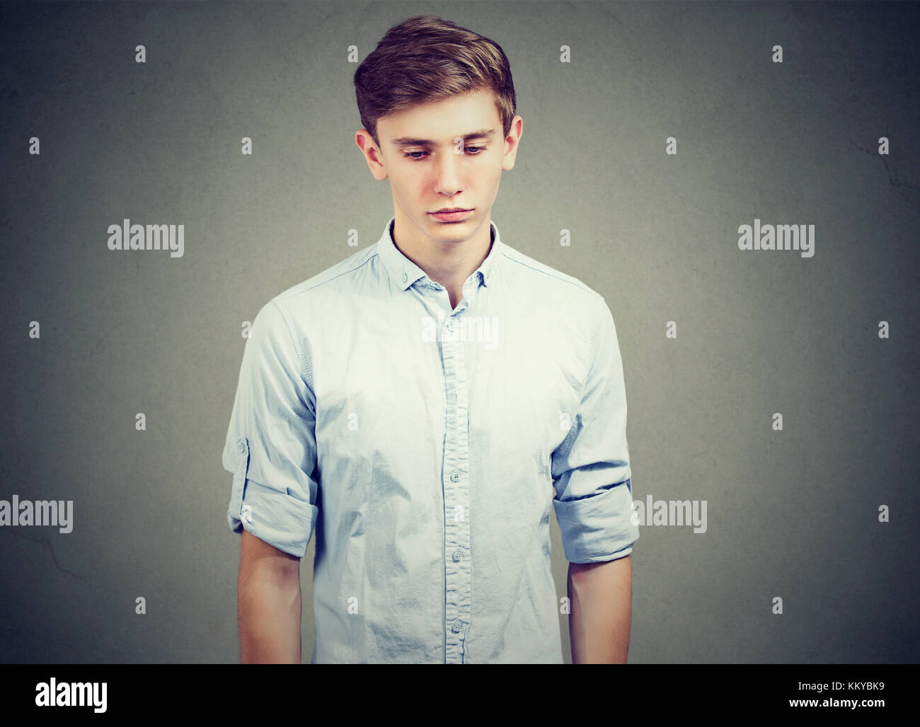 Profile view of sad young man looking down Stock Photo - Alamy