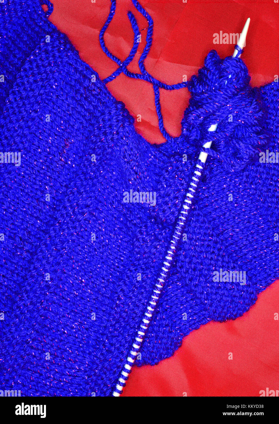 Lurex fibre twined blue woollen scarf on needles Stock Photo