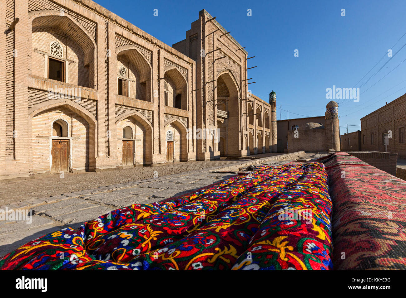 Old madrassa and Uzbek tapestry in Khiva, Uzbekistan. Stock Photo