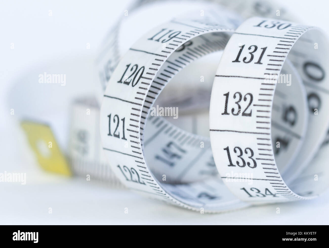 Curved measuring tape. Measuring tape of the tailor. Closeup view of white measuring tape Stock Photo