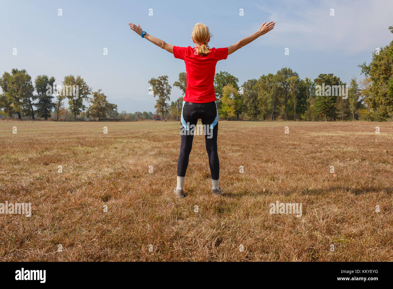 a woman is doing gymnastics in a park /a healthy lifestyle of a fifty-years-old woman practicing gymnastics in a park Stock Photo