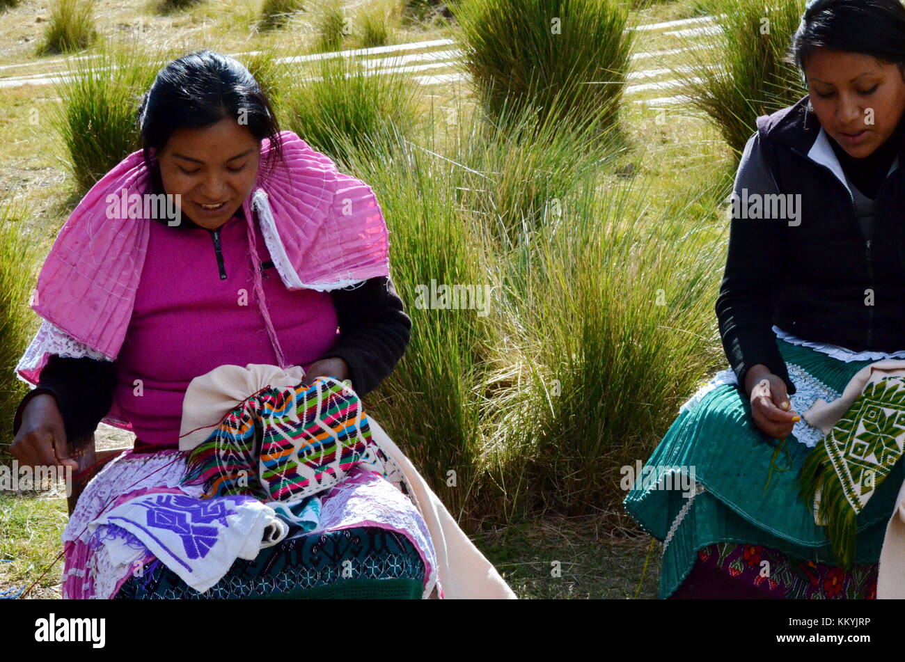 Mexican indigenous women hand sewing colorful textiles in Mexico Stock