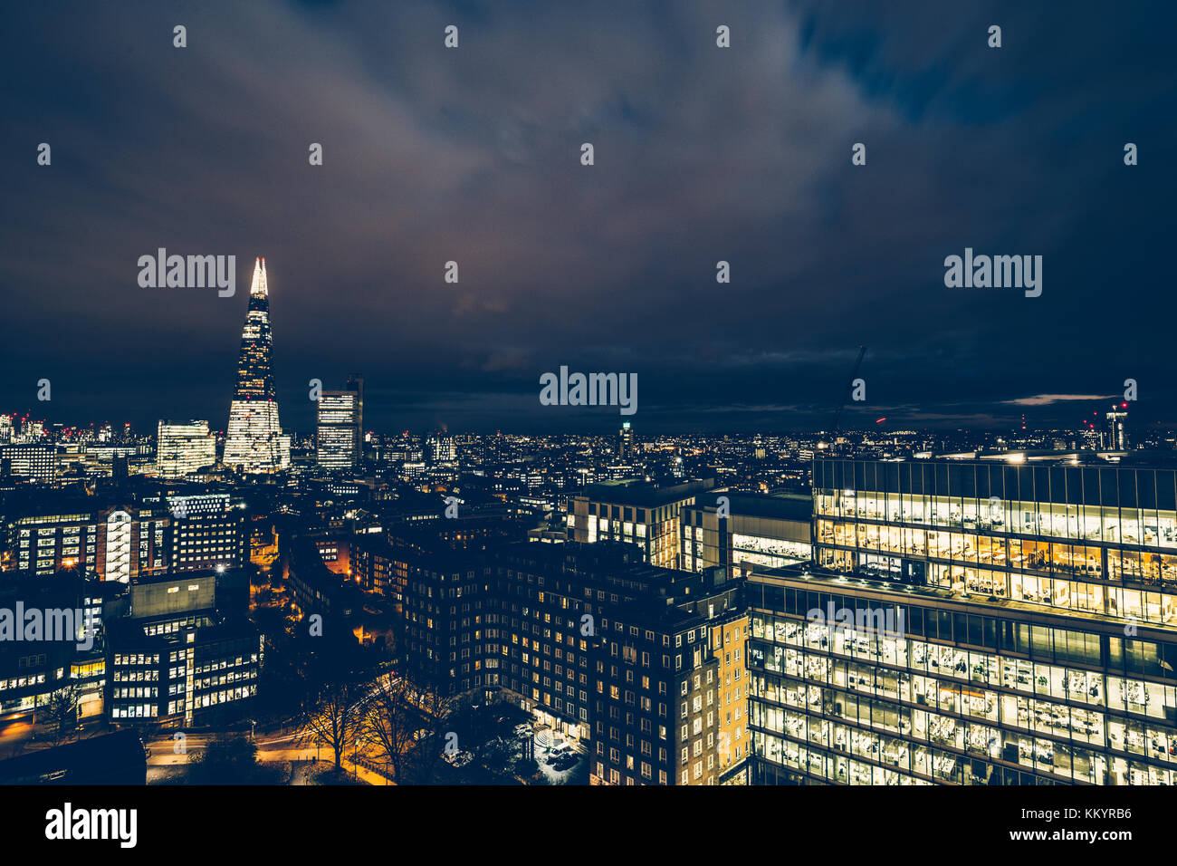 Aerial cityscape view of rooftops and office buildings on modern London skyline at night Stock Photo