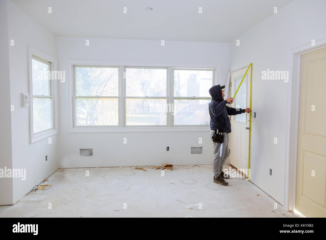 Carpenter brad using nail gun to moldings on doors, framing trim, with