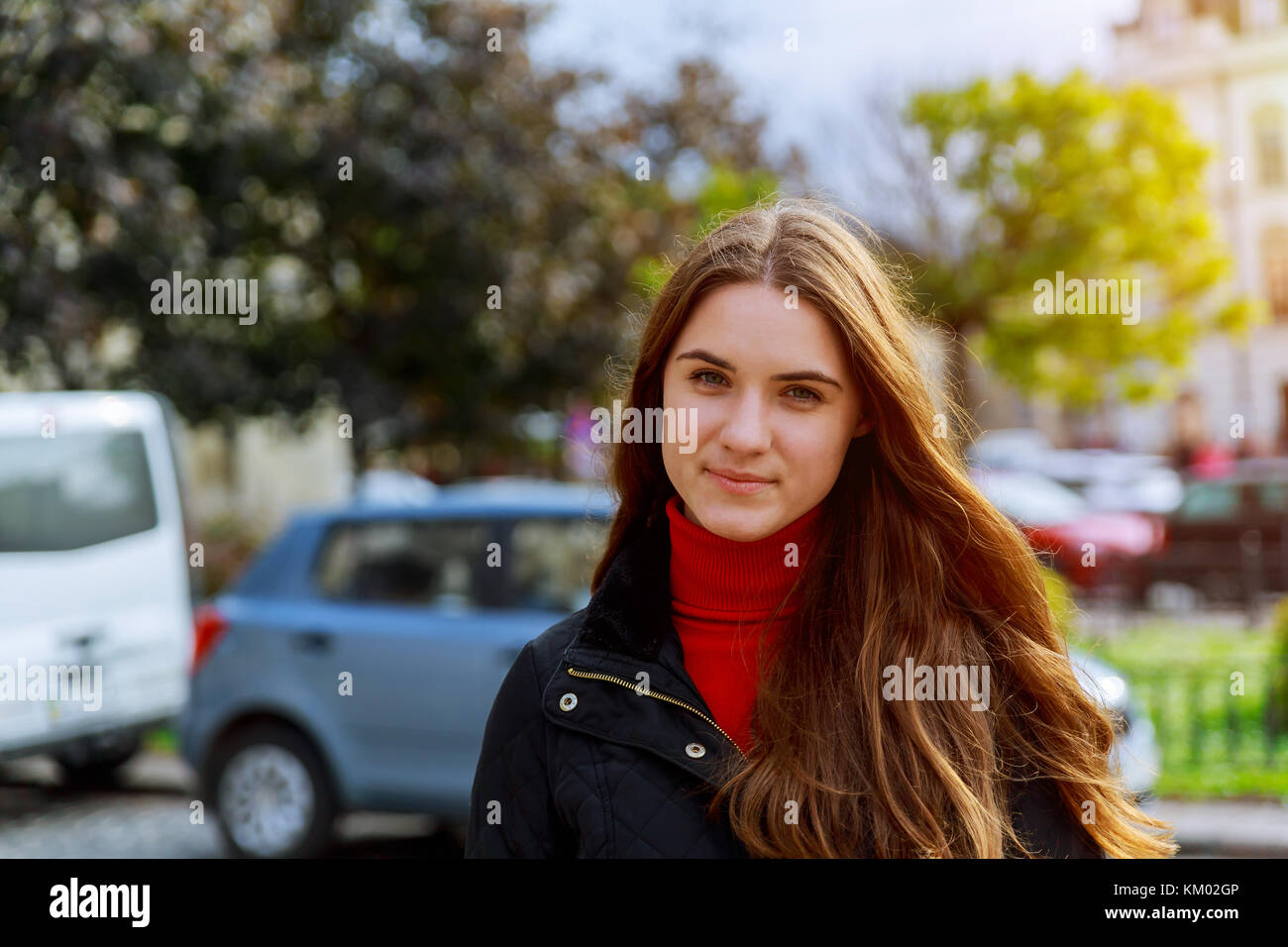 Beautiful brunette young woman wearing dress and walking on the street ...