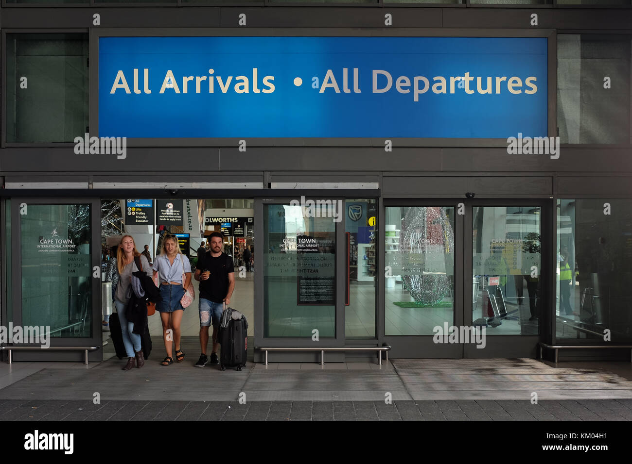 People carrying luggage walk through the entrance to Cape Town