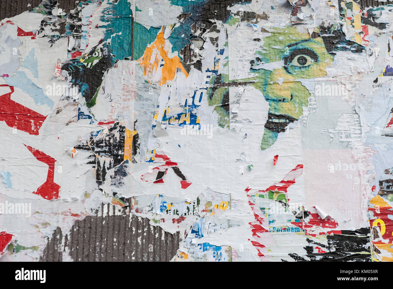 Wall full of Scraped posters, a printed female face is partial visible. Stock Photo