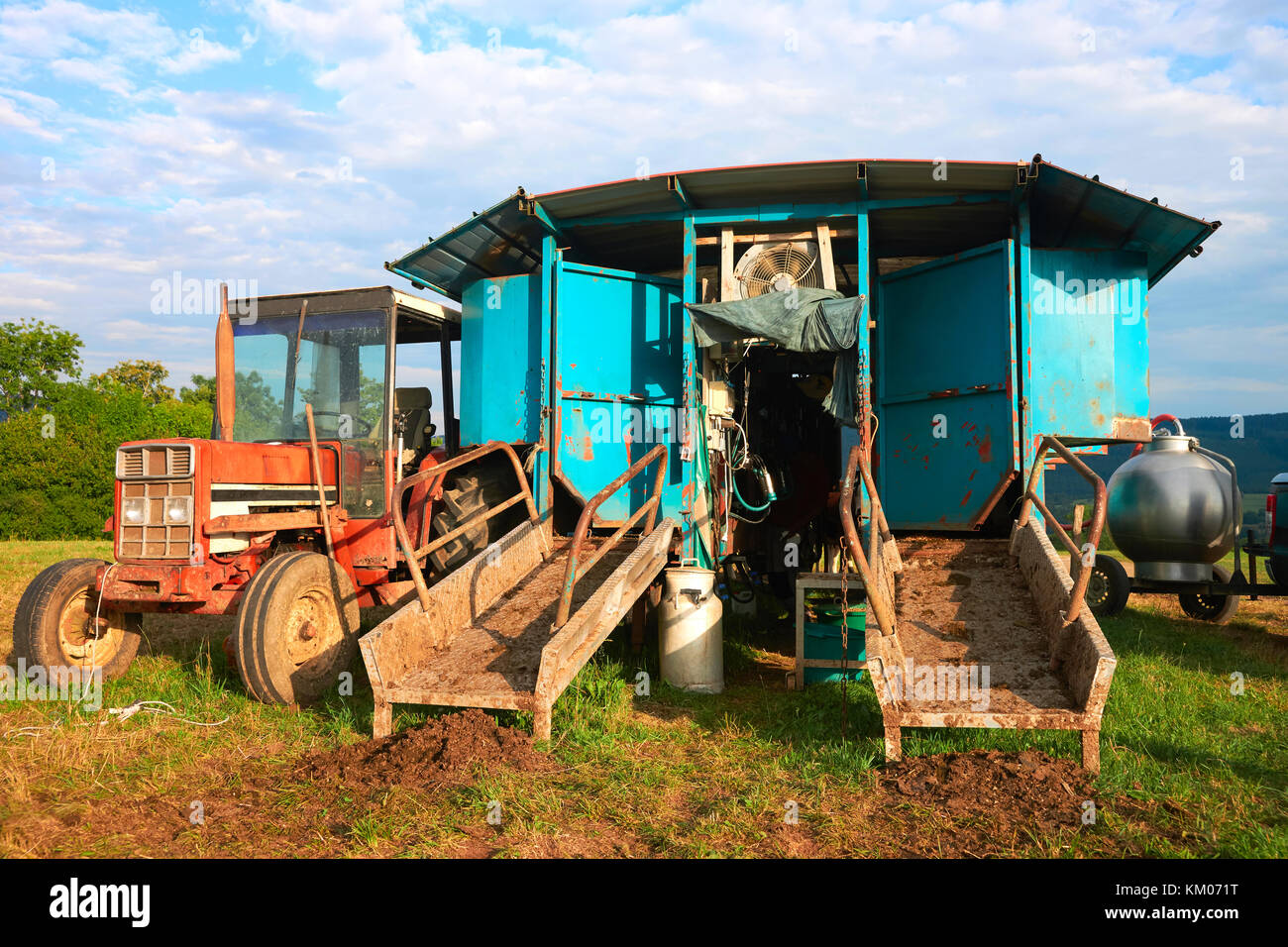 Tractor and milking parlor in the pasture, Franche Comte, France. Stock Photo