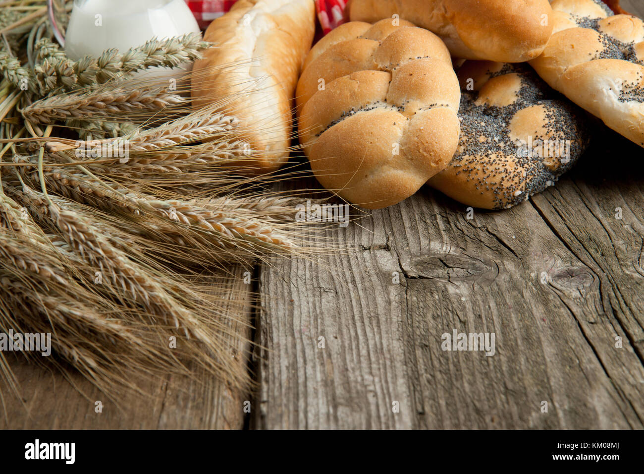 Lot of bread and spikes of rye on old wooden table as background Stock ...