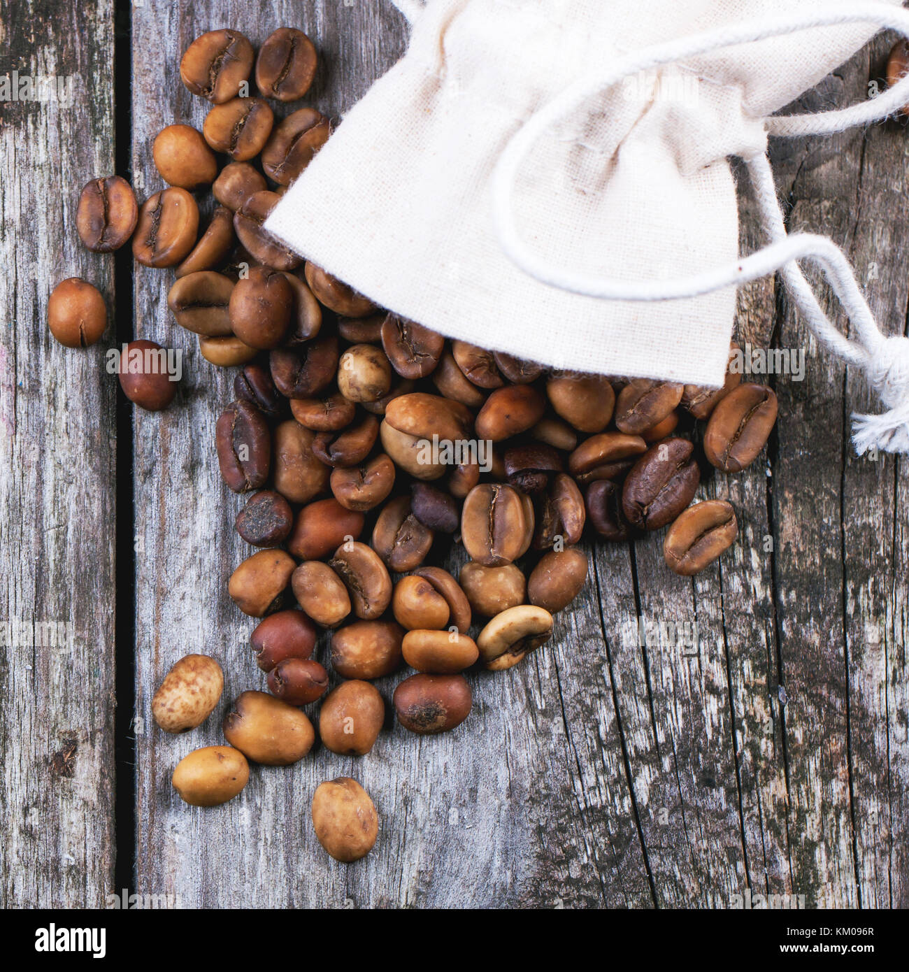 Sack with unroasted decaf coffee beans over wooden background. Top view. Square image Stock Photo