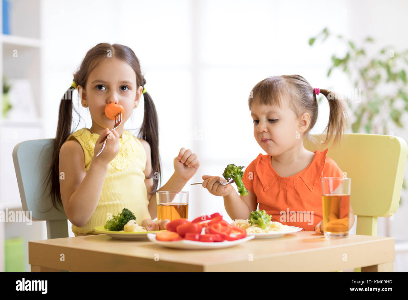 Little discontented children does not want to eat pasta with vegetables Stock Photo