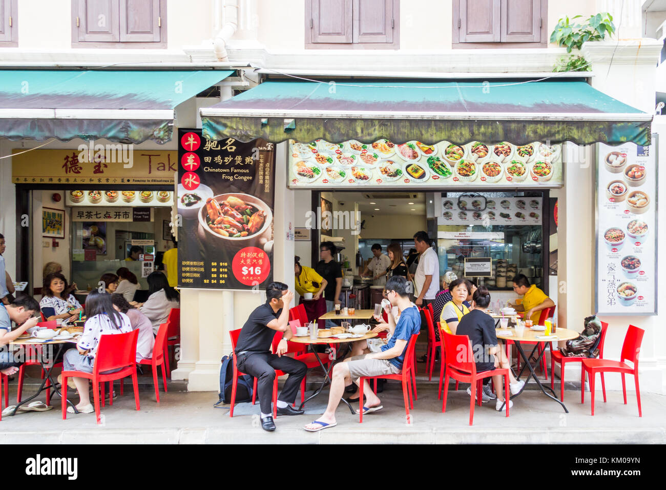People eating on the street outside a restaurant in Smith street, Chinatown, SIngapore Stock Photo