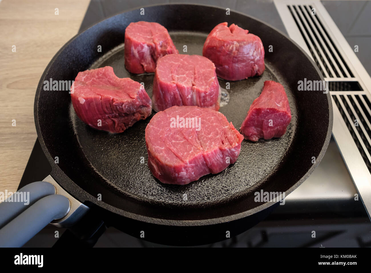 Raw beef fillet roasting in a cast iron frying pan on a stove Stock Photo Alamy