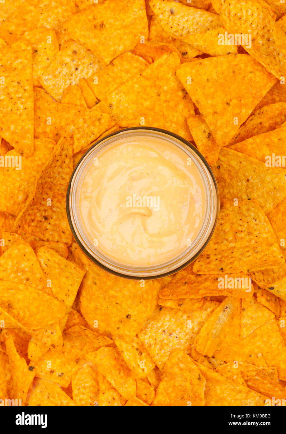 Glass container with cheese dip and nachos chips top view Stock Photo