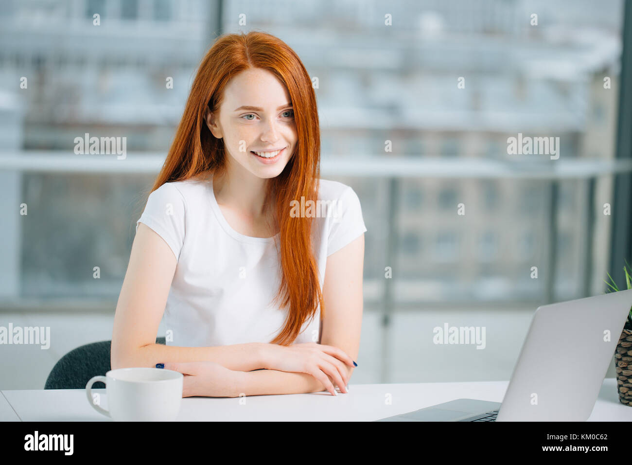 beautiful redhead girl works at laptop and looking at camera Stock ...