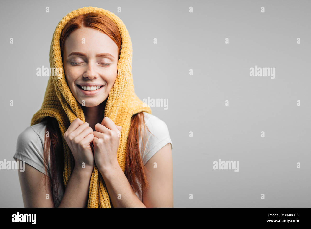 redhead girl wearing knit sweater on head as headscarf Stock Photo