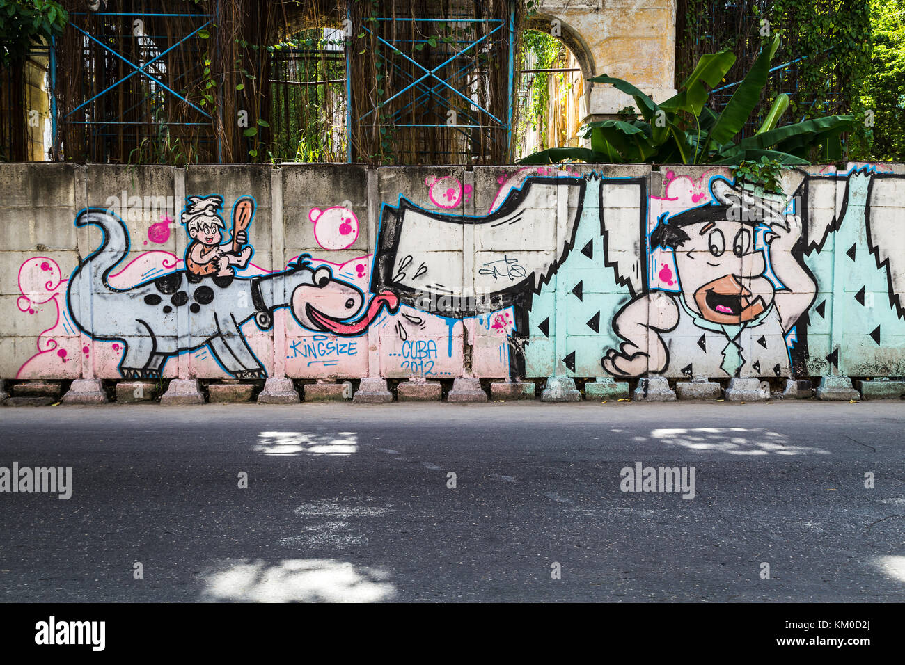 Painting of Fred Flinstone & Dino (being ridden by Pebbles) on a wall in Havana, Cuba. Stock Photo