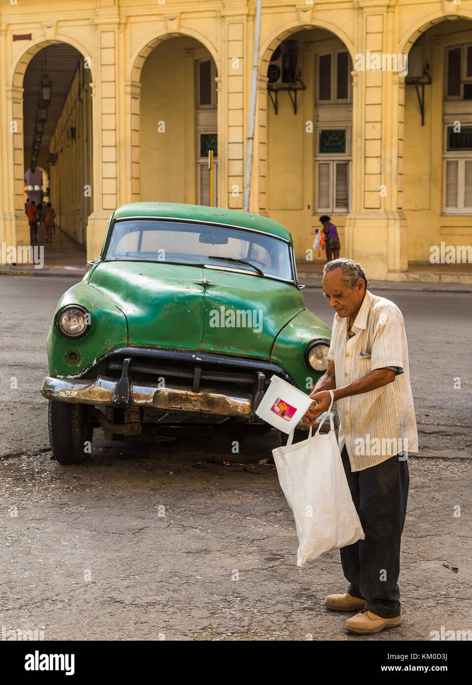 A man seeing collecting plastic objects to fill a bag on the streets of Havana during the summer of 2014. Stock Photo
