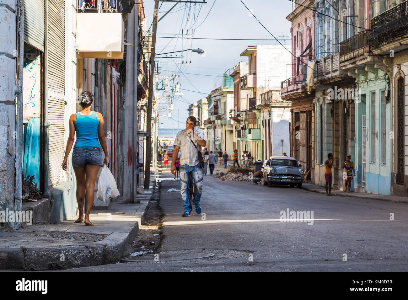 Local people of different ages and wearing varying colours of clothing go about their lives in Centro Havana during November 2015.  The Straits of Flo Stock Photo
