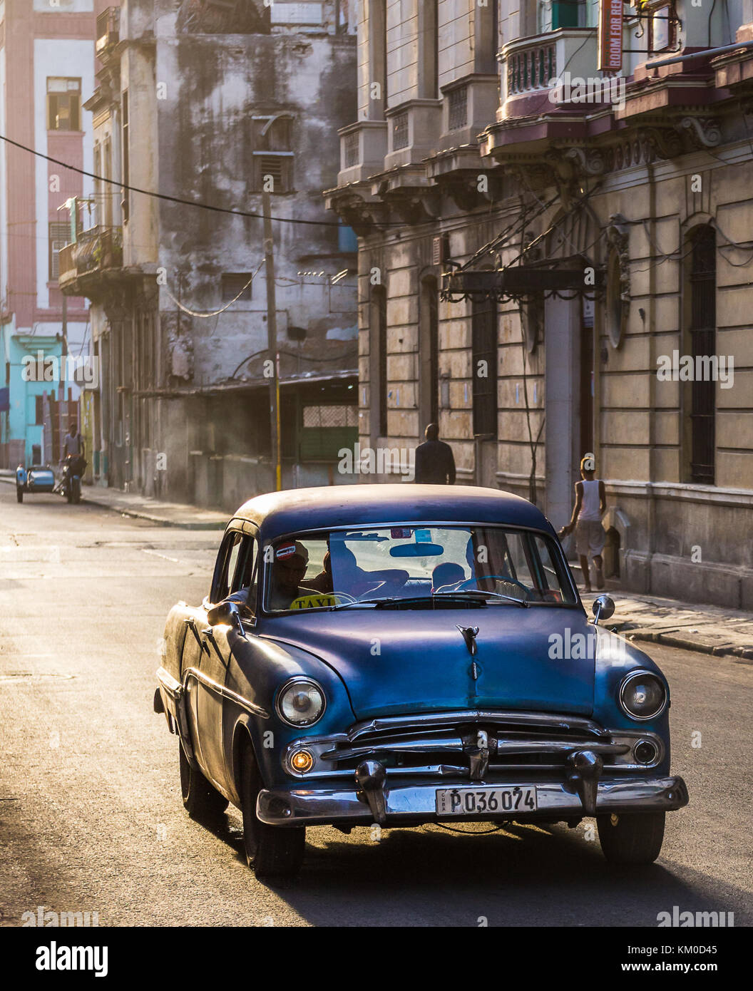 The golden light of another stunning Caribbean sunset bathes a purple classical car in soft light one evening in Centro Havana during August 2014. Stock Photo