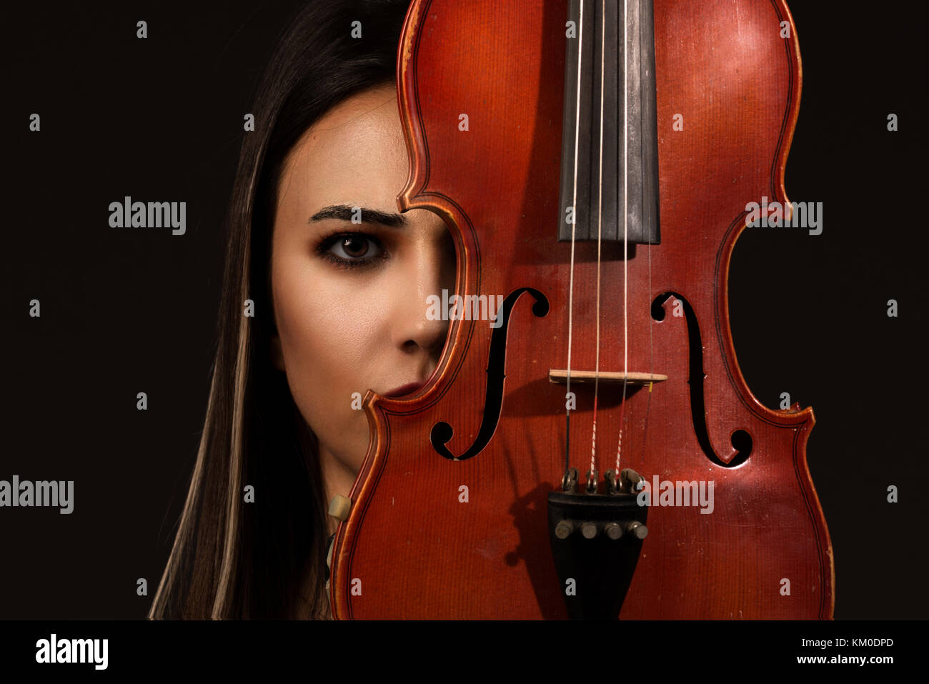 Beautiful Violinist Woman playing violin on black background Stock
