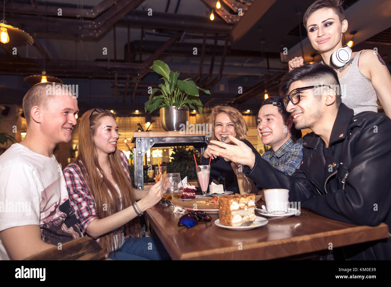 friends having a coffee together. women and man at cafe, talking, laughing Stock Photo