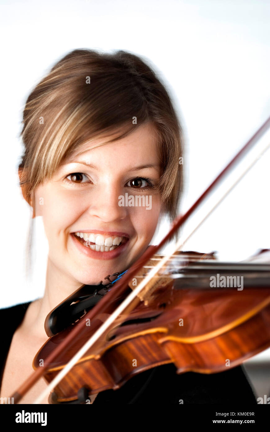 Young girl smiling and playing the violin Stock Photo - Alamy