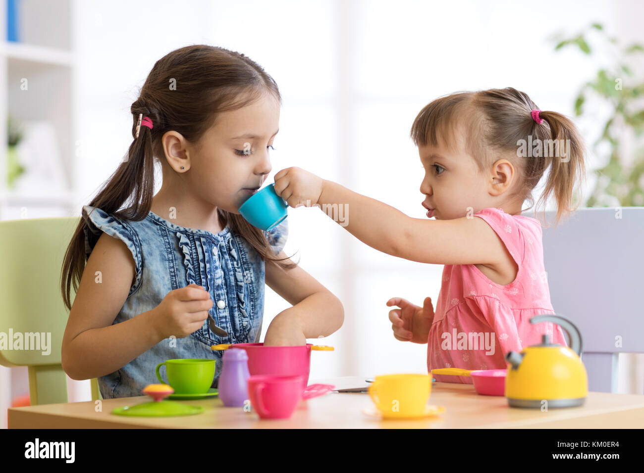 Kids playing with plastic tableware Stock Photo