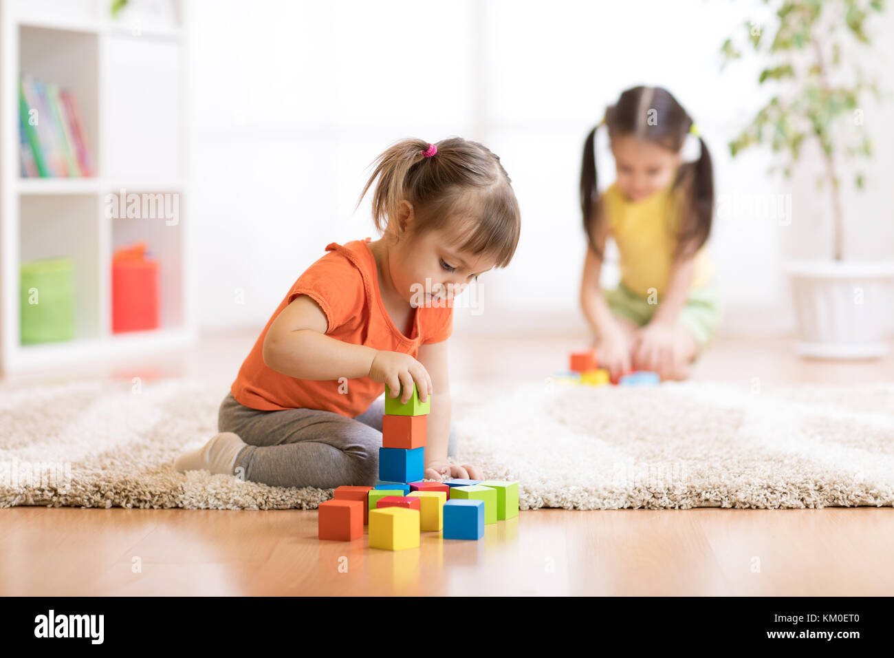 Children toddlers girls playing toys at home, kindergarten or nursery Stock Photo