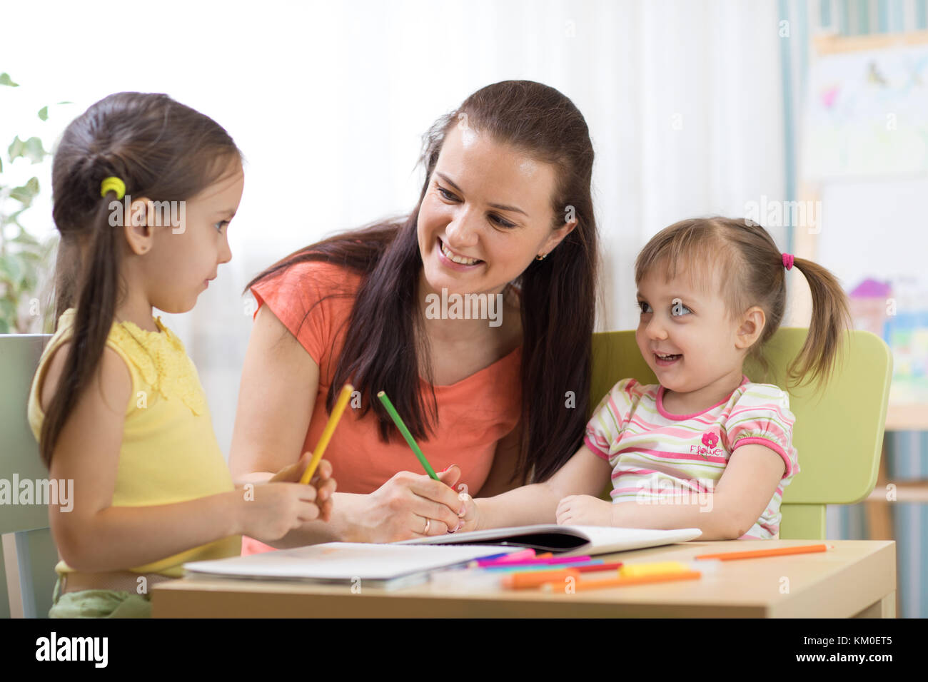 Teacher mom working with creative kids Stock Photo
