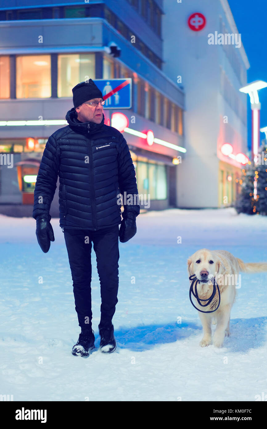 Rovaniemi, Finland - March 1, 2017: Man with Labrador dog in winter Rovaniemi, Finland. Stock Photo