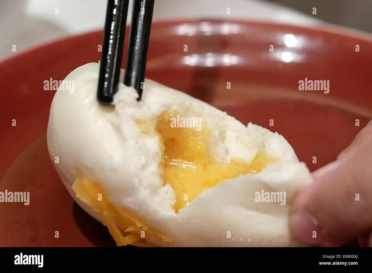 Motion of people eating steamed egg yolk bun inside restaurant Stock Photo