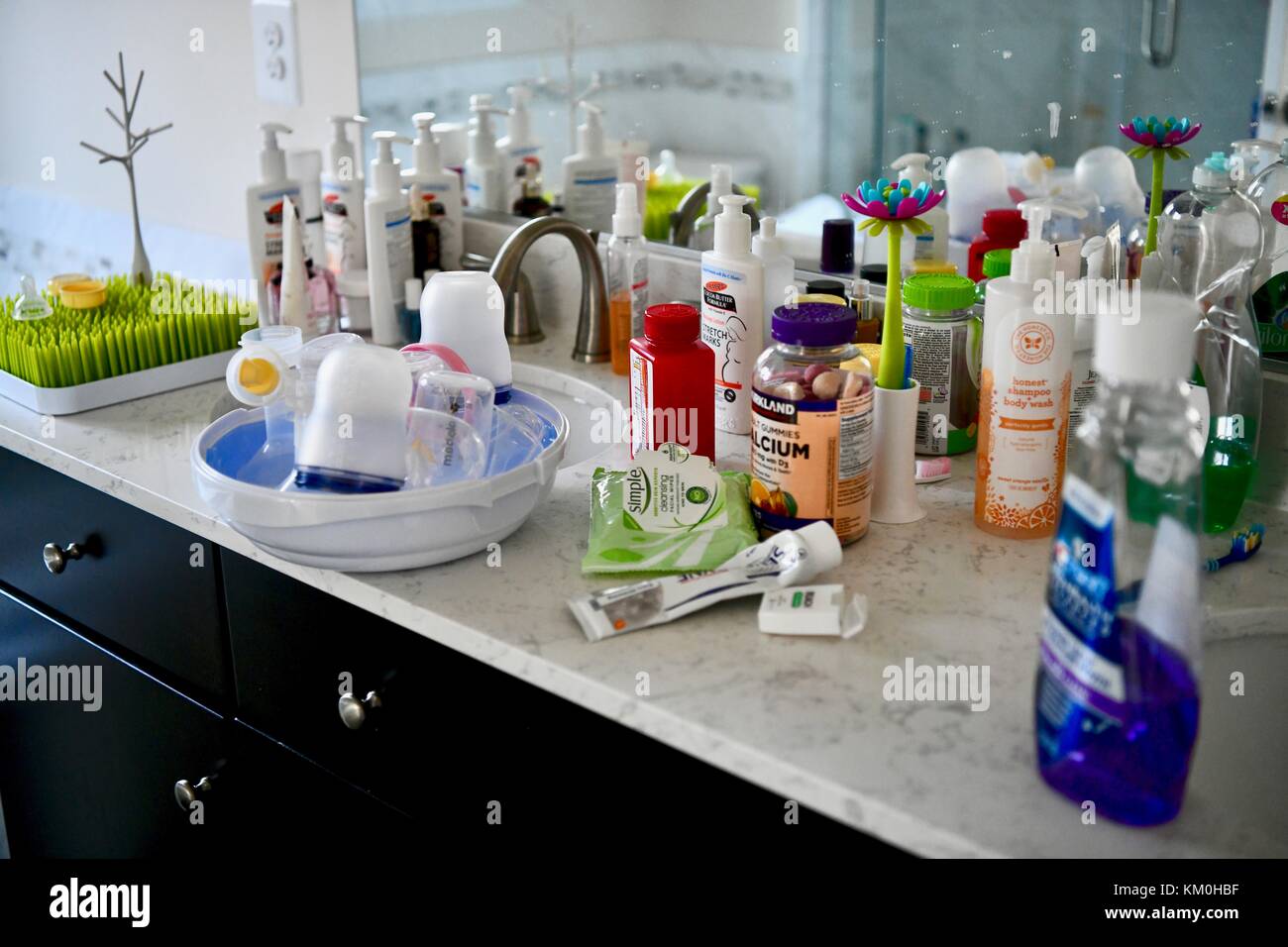 Bathroom counter covered in bathroom products and supplies Stock Photo