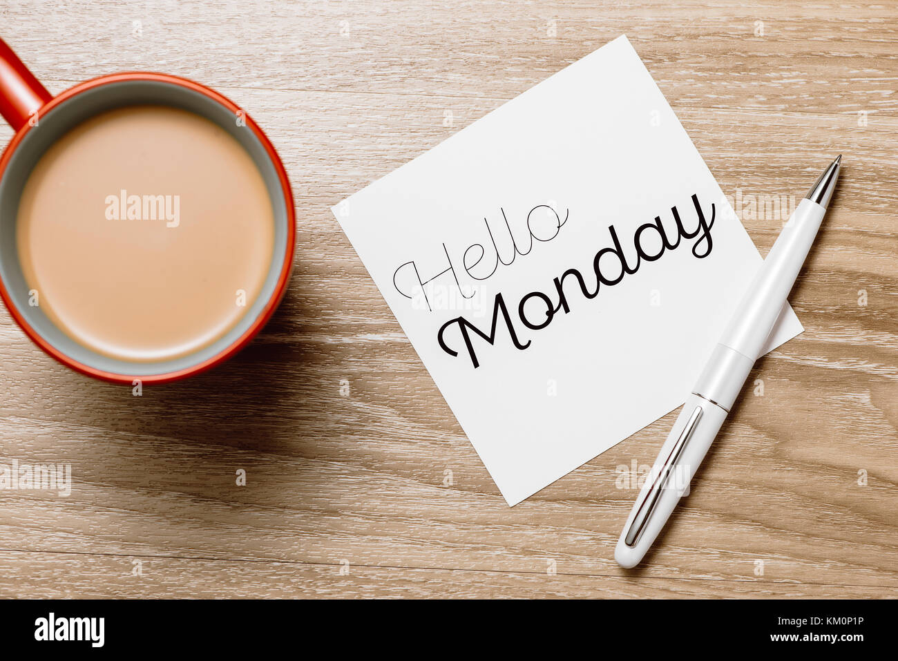 Good morning Monday - cheerful message on a sticky note with a cup of coffee and pen Stock Photo