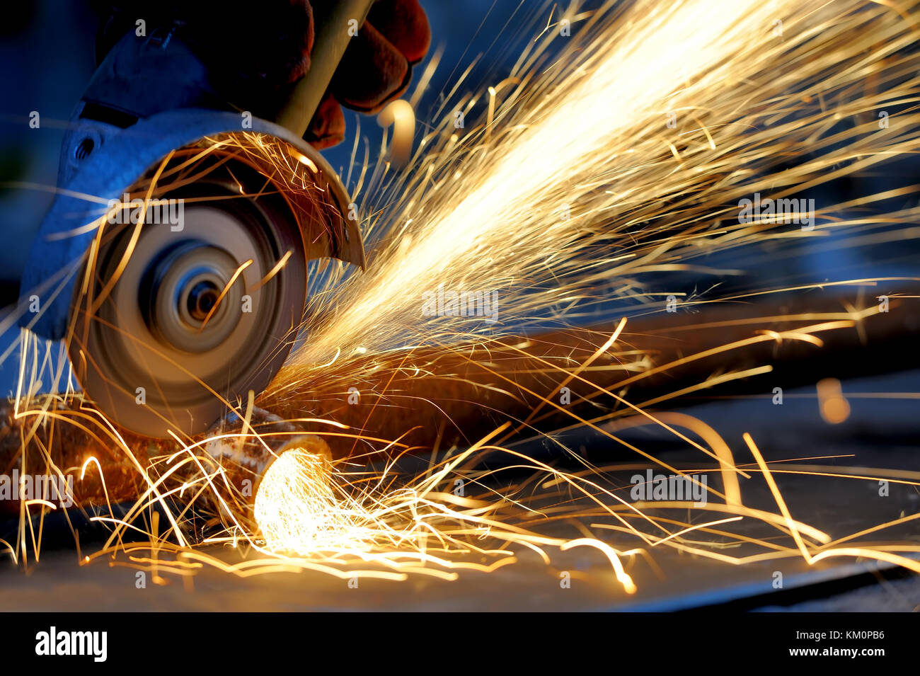 Worker cutting metal with grinder. Sparks while grinding iron Stock