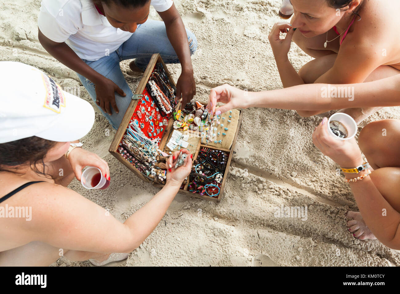 Saona island, Dominican Republic - January 7, 2017: Women are considering the range of goods of a street vendor with assortment of traditional Dominic Stock Photo