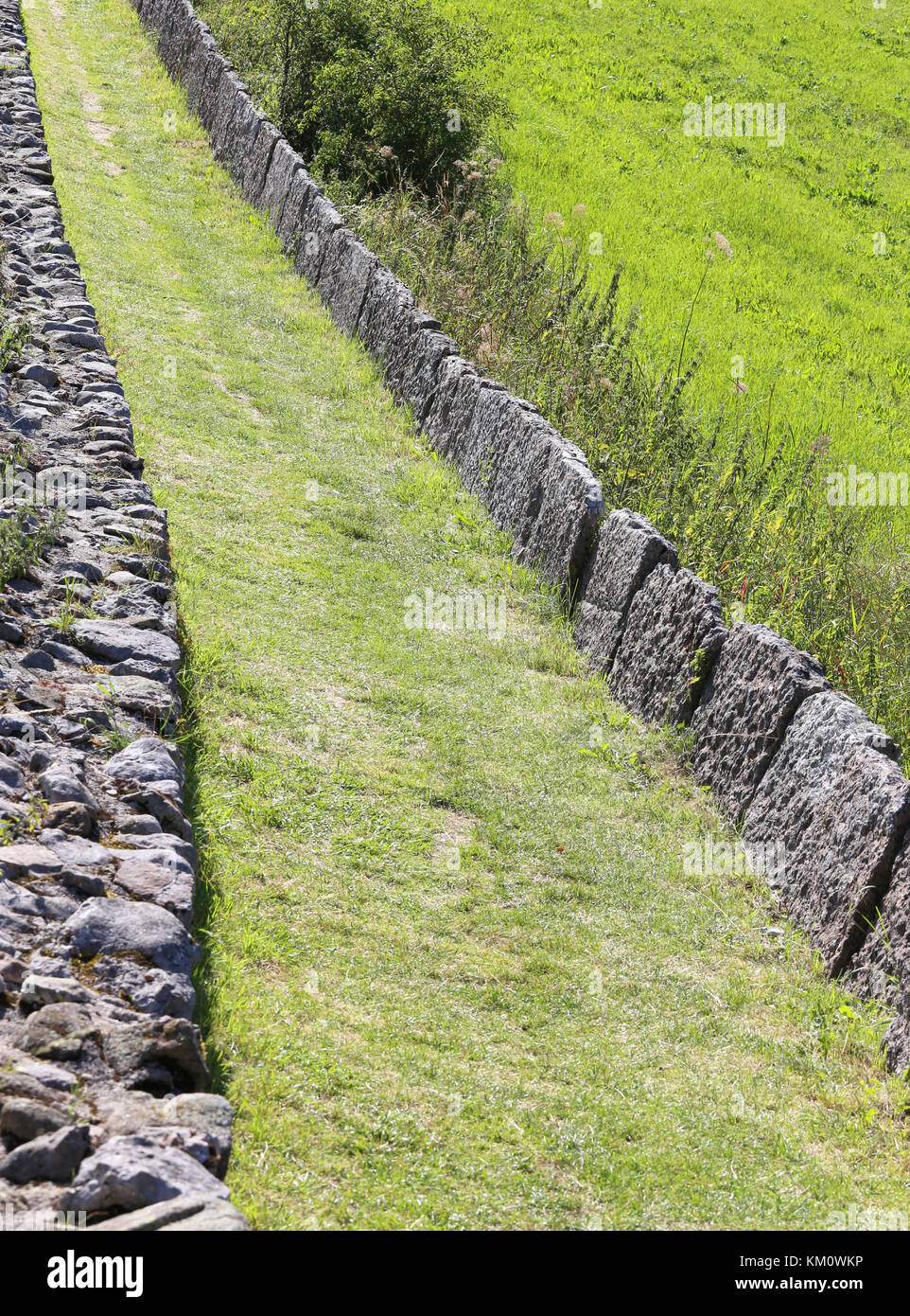 mountain path bordered by large stone blocks Stock Photo