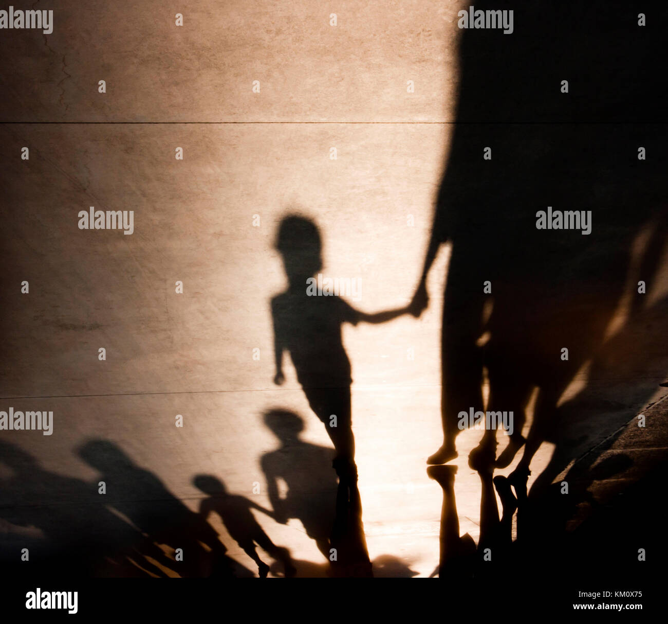 Raising confident child : Blurry shadows silhouettes of families with kids  walking and holding hands on misty summer promenade, childhood memories Stock Photo