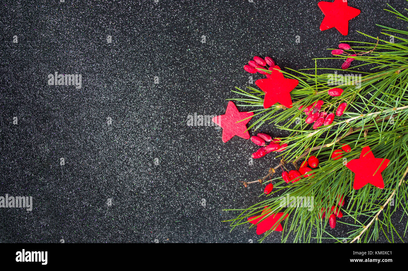 Red Christmas decorations and fir tree on dark shiny background Stock Photo