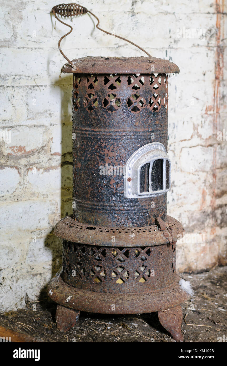 Old, antique paraffin heater, covered in rust.  Heaters like this were common in Irish homes at the start of the 20th Century. Stock Photo
